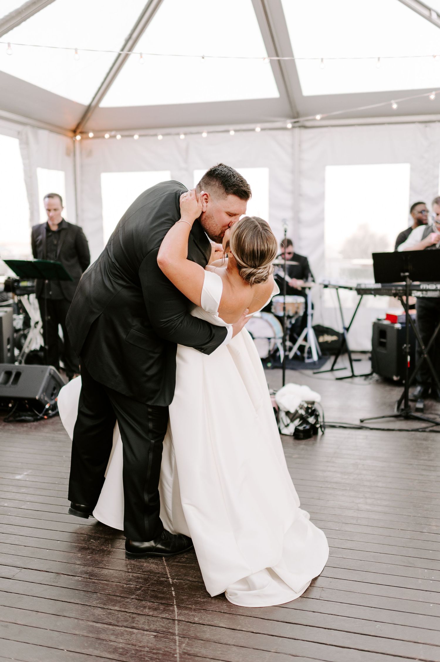 Romantic dance sequence showing wedding couple's intimate moments on wooden deck under white tent.