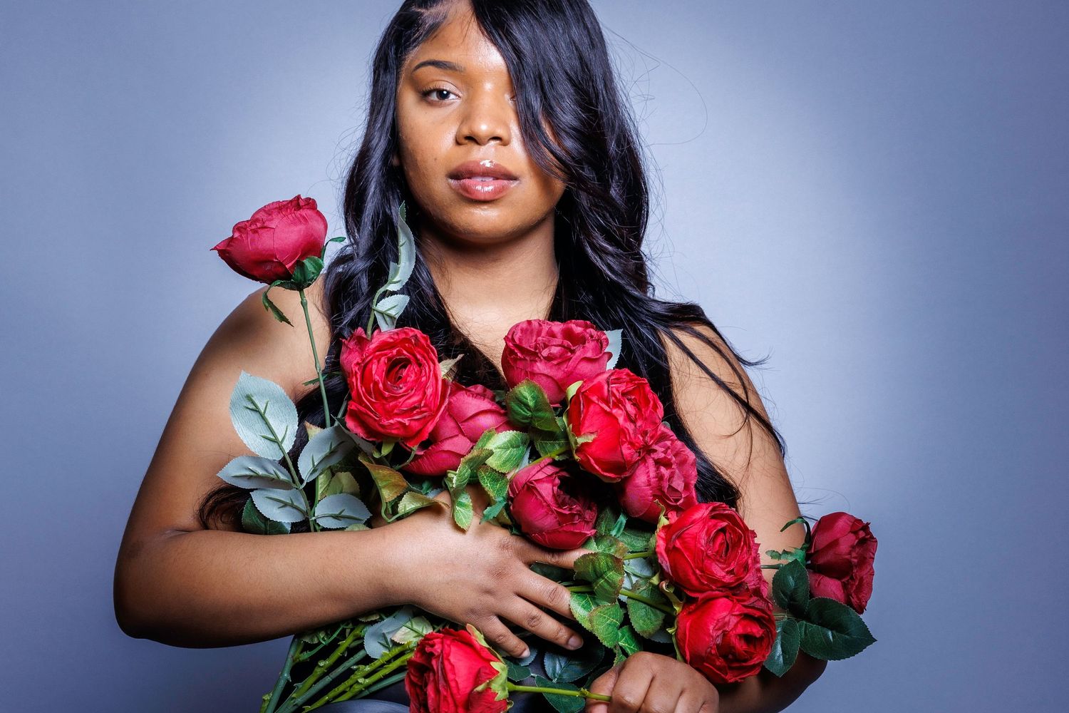 Person holds bouquet of red roses in series of elegant portrait shots against blue background.