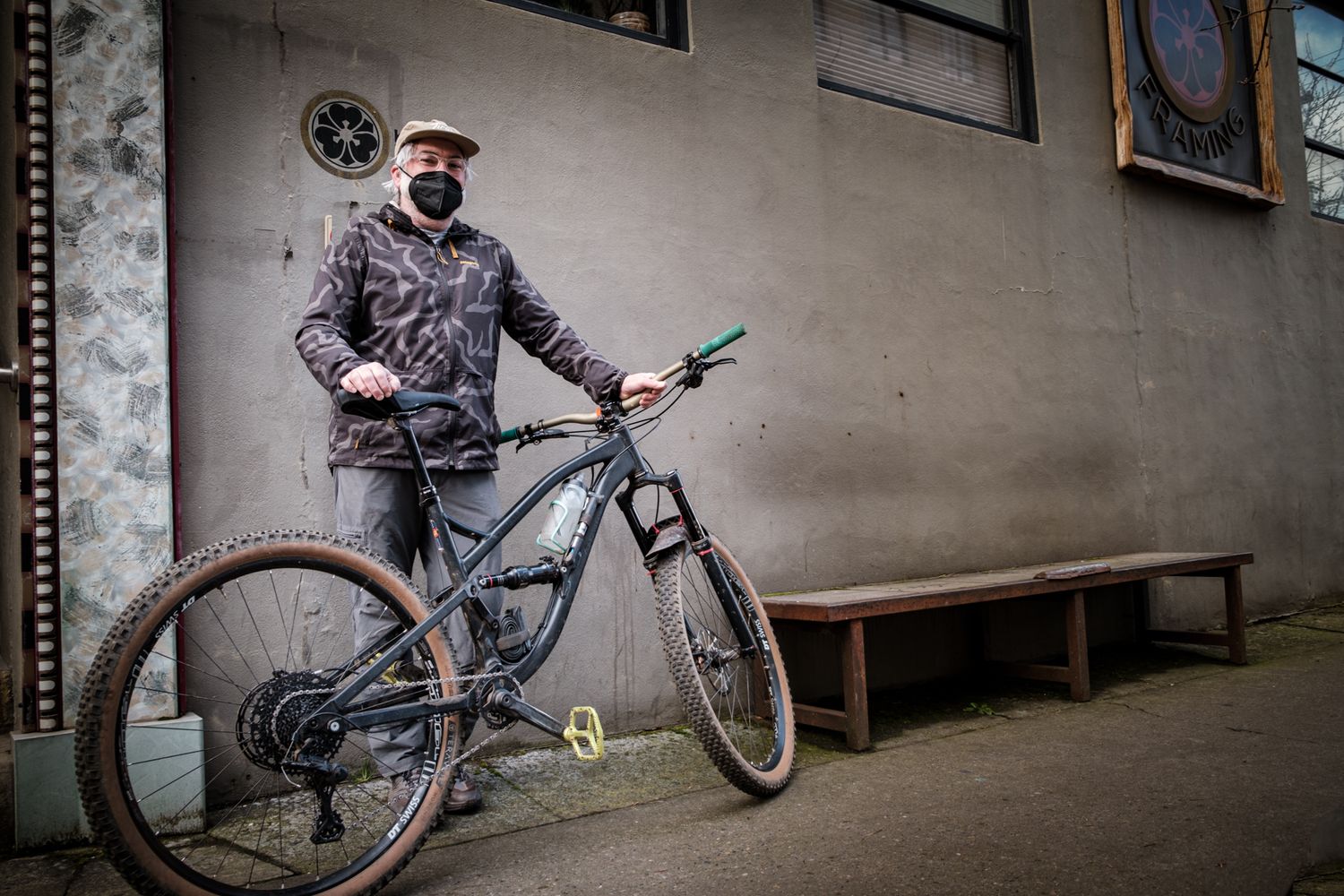 BMX rider performs stunts against industrial concrete wall in black and white composition.