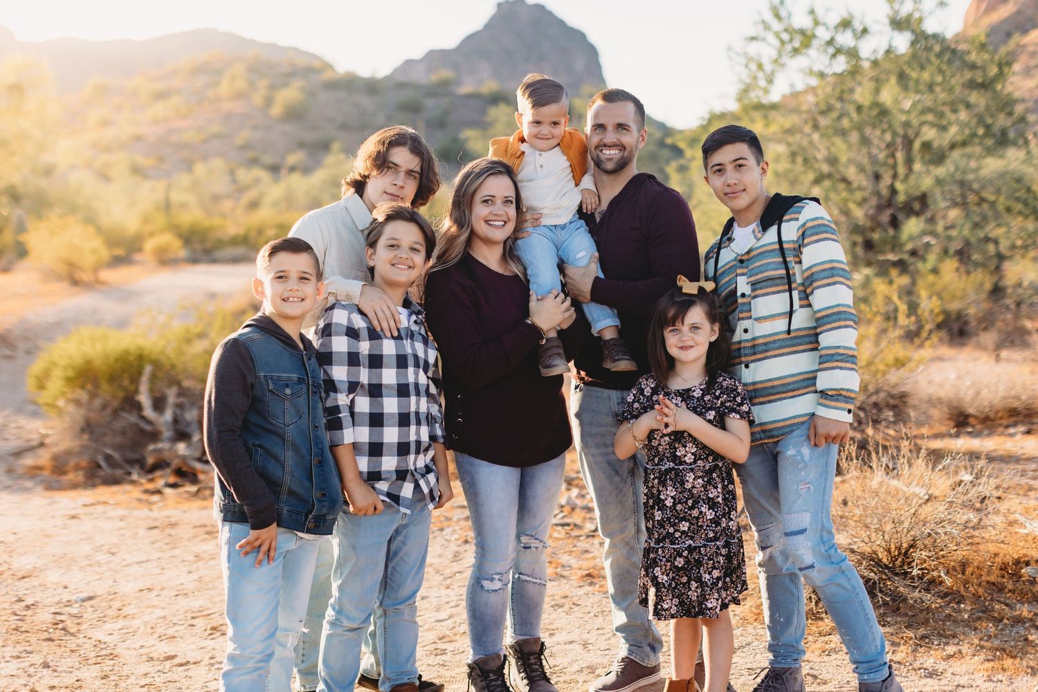 Family portrait session in desert landscape with mountains and sunset lighting.