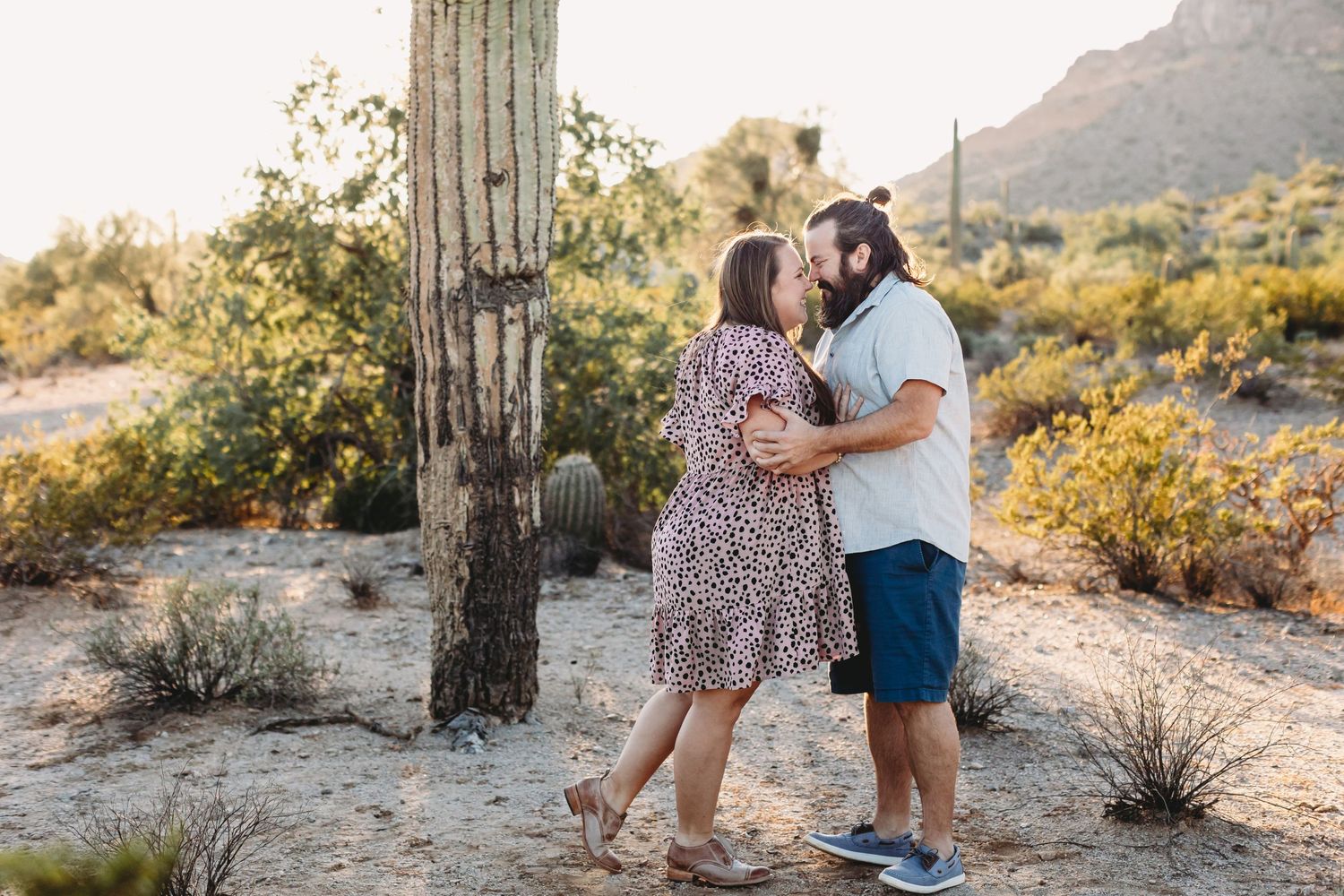 Family portraits taken at sunset near a large saguaro cactus in the desert.
