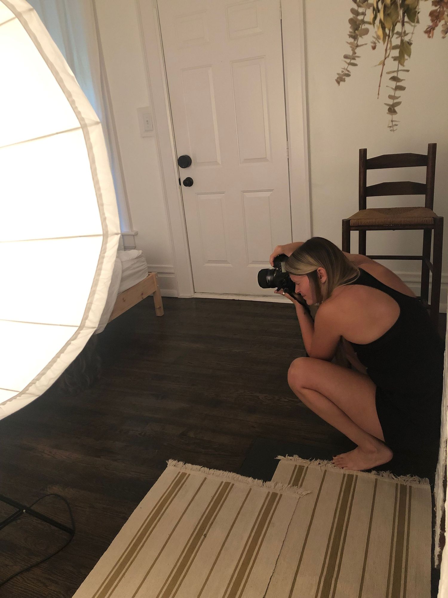 Photography setup with lighting equipment and wooden floors in an indoor studio space.