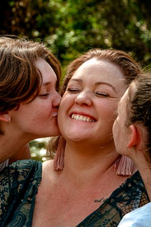 Candid moment of affection and laughter between friends outdoors.