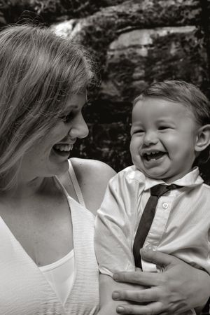 Black and white candid portrait showing joyful laughter and connection.