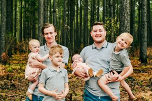 Family photoshoot in a forest setting showing natural interactions and casual poses.