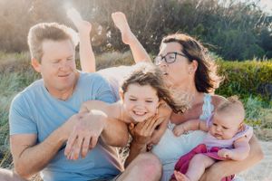 Family members embracing and laughing together during an outdoor photo session.