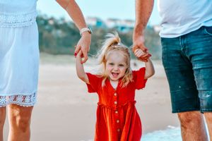 Candid moments of family members playing and interacting on a sunny beach.
