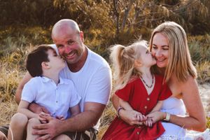 Family enjoying a casual outdoor photo session in golden autumn light.