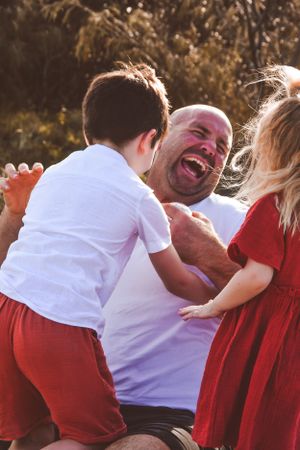A joyful moment of laughter and play between family members wearing red and white outfits.