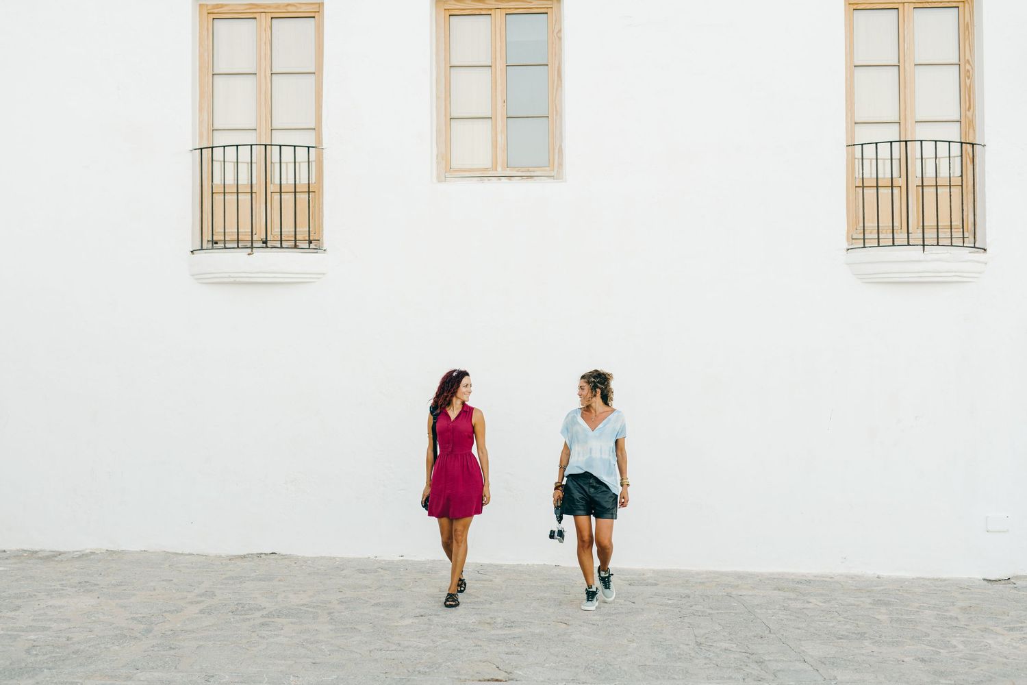 Two female photographers walk and laugh together