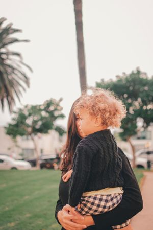Sunset family moment with palm trees creating a warm California backdrop.