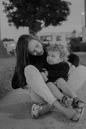 A sweet monochrome portrait of two people sharing a moment while sitting on a pathway.