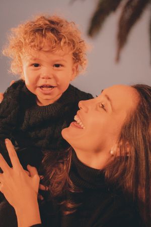 Candid moment between parent and child wearing matching black sweaters.