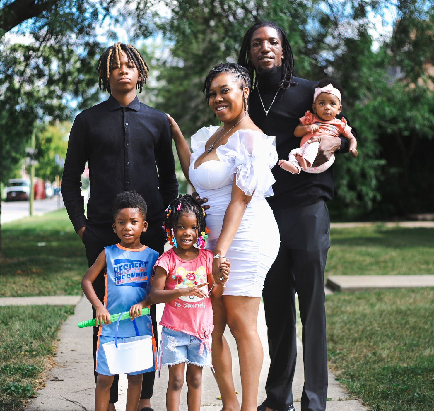 Photo of a family standing on a sidewalk.