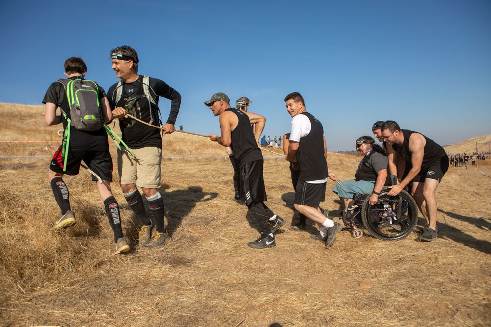Participants traverse rough terrain during an outdoor sporting challenge.