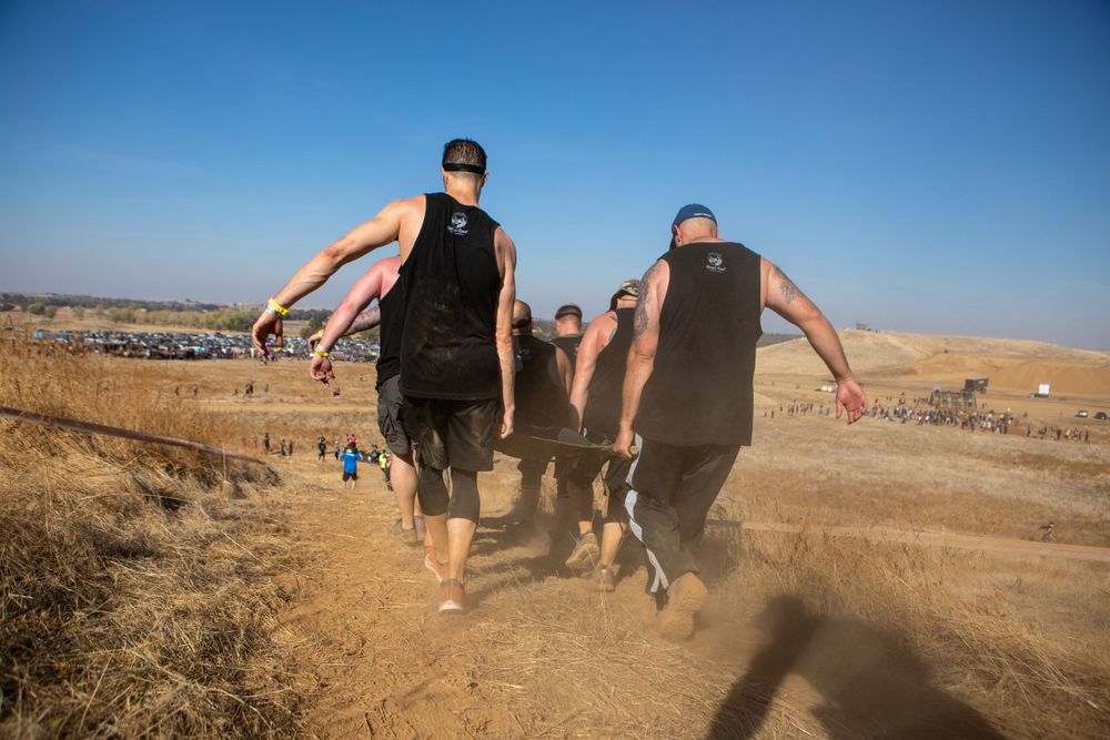 Participants run together on a dusty trail during an outdoor endurance event.