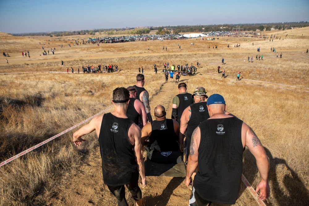 Athletes descend a steep hill during a challenging obstacle course race.