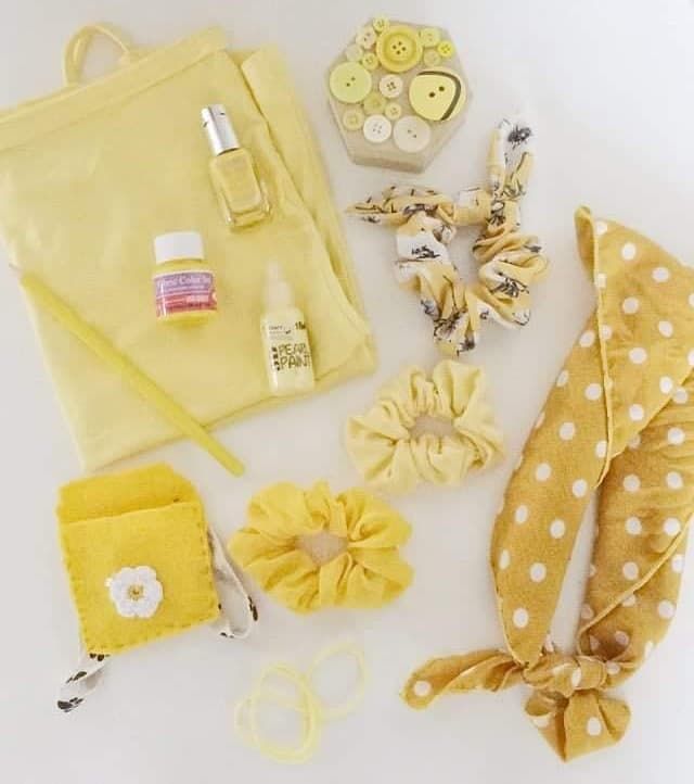 Yellow-themed accessories collection including bag, hair clips, and beauty products.