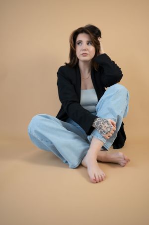Portrait of women posing with hands playful in her hair sitting on the ground. Wrightstown NJ Photographer