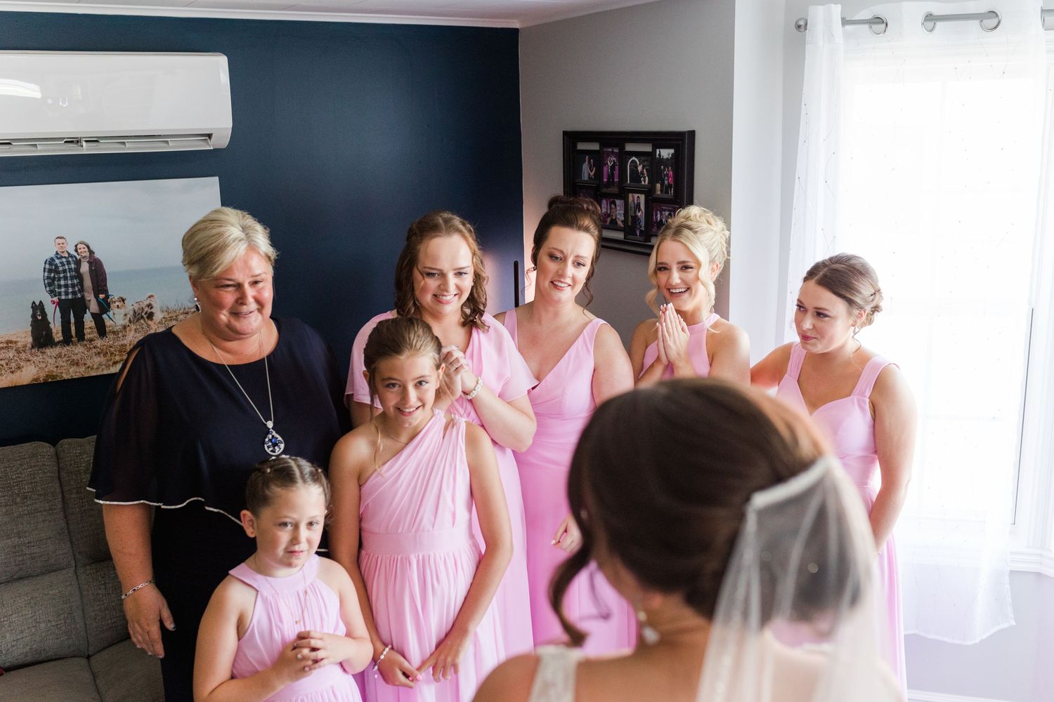 Wedding party members in pink dresses gather for a special moment before the ceremony.