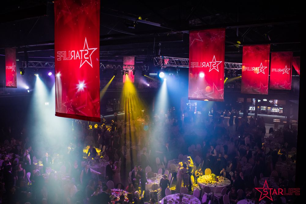 Nightclub interior with colorful lighting and Star-branded banners hanging from ceiling.