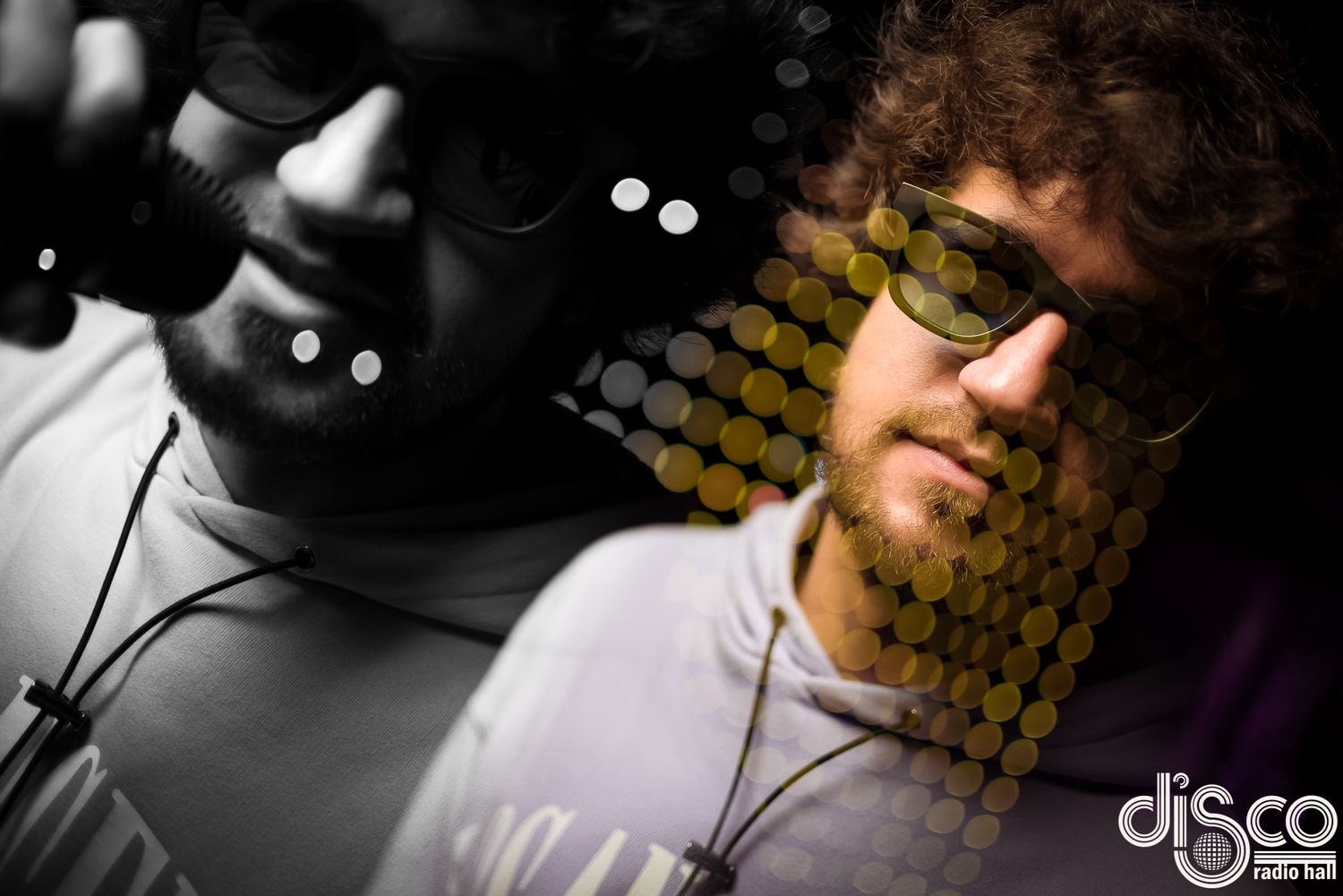 DJ wearing glasses photographed in black and white with honeycomb pattern overlay.