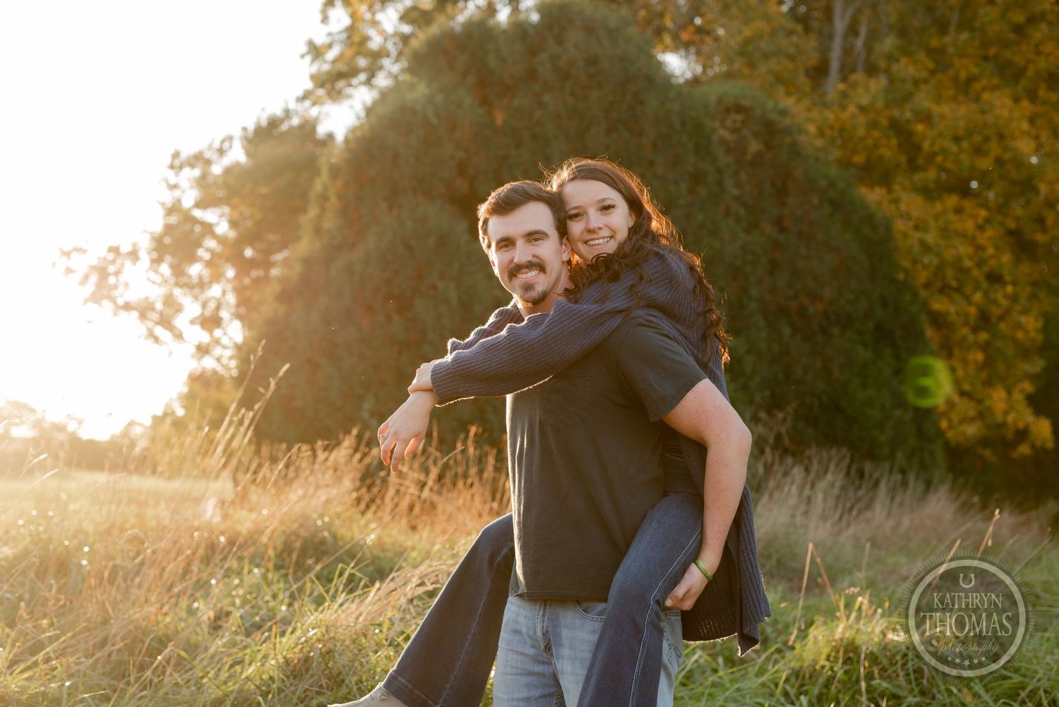 A piggyback ride moment captured against autumn foliage during sunset.