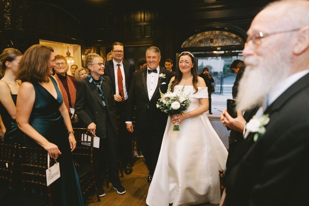 Elegant celebration taking place in a historic venue with decorative lighting and dark wood details.