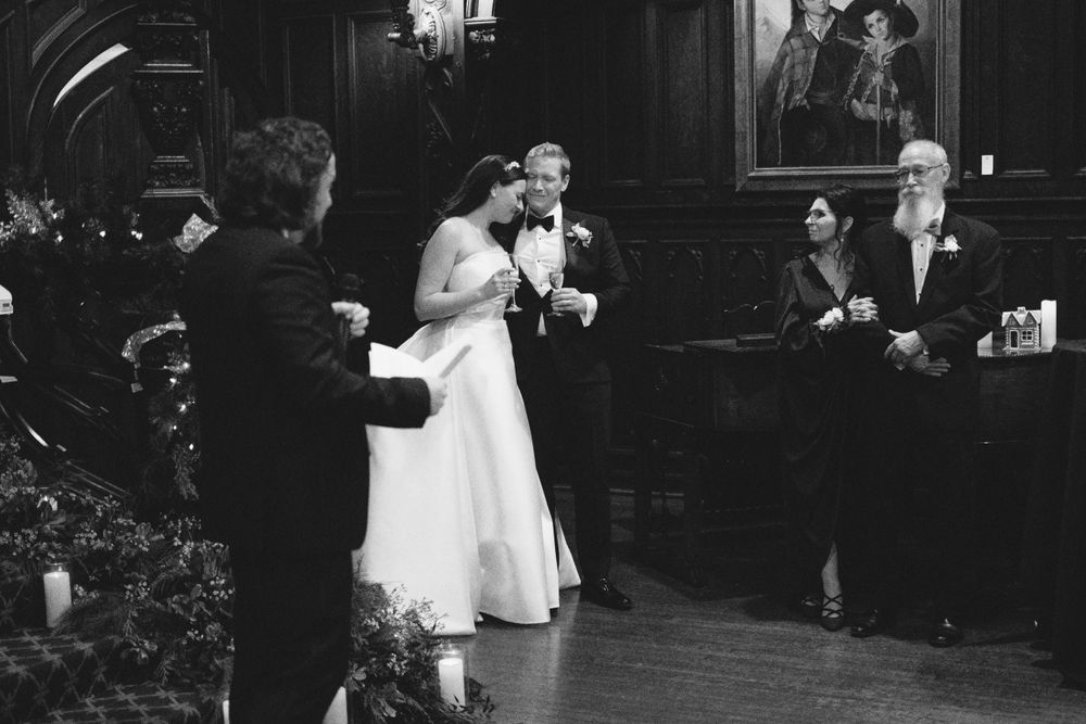A wedding celebration moment captured in black and white in an elegant indoor venue.