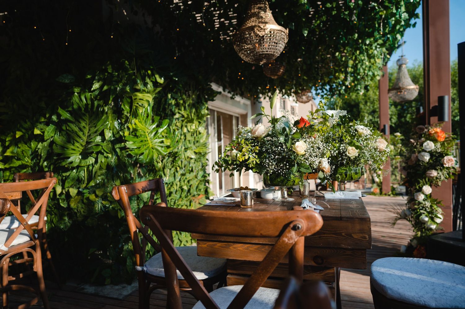 Outdoor wedding venue decorated with hanging lanterns and lush greenery.