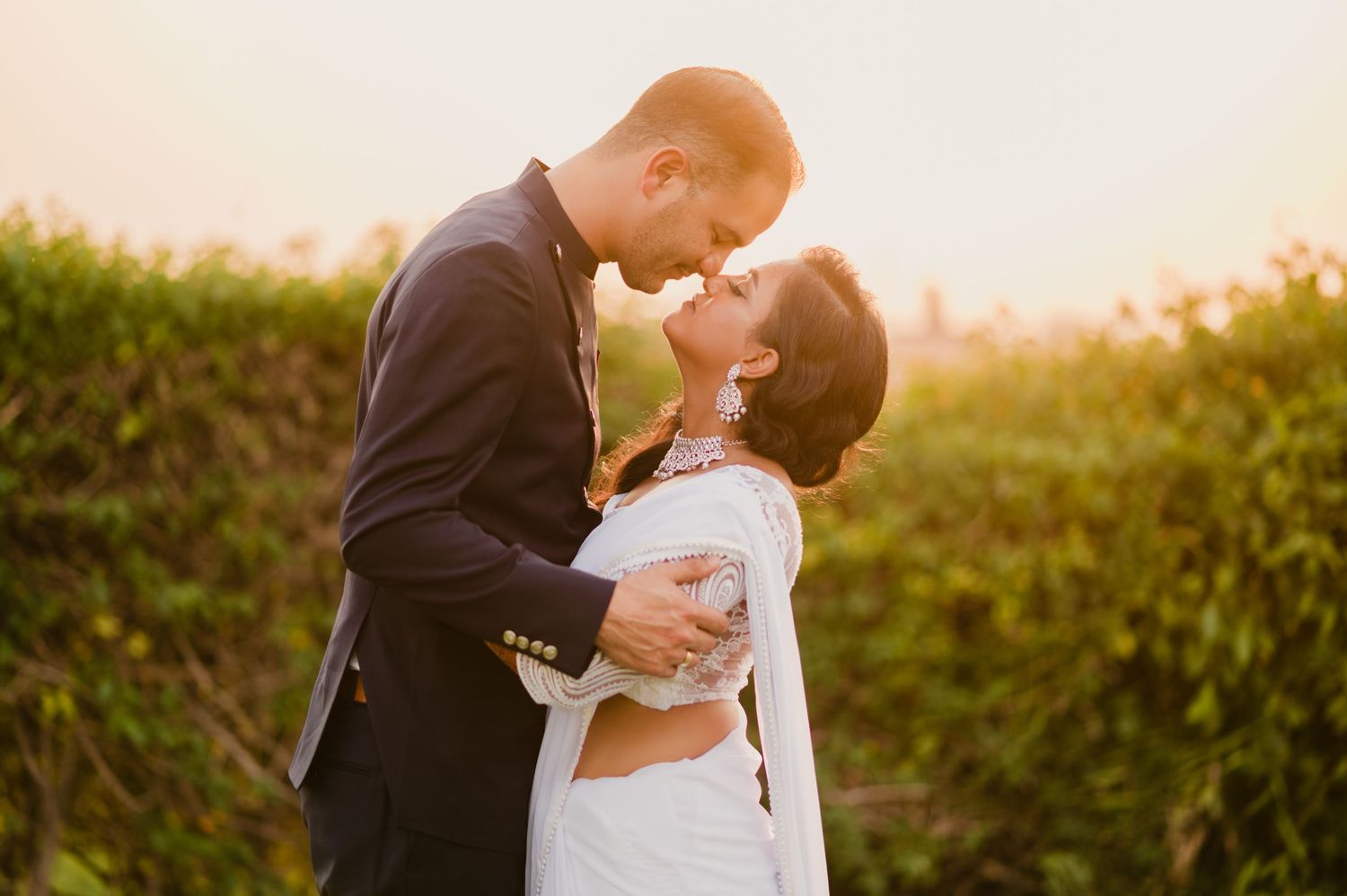A tender sunset wedding portrait showing an intimate moment between the couple.