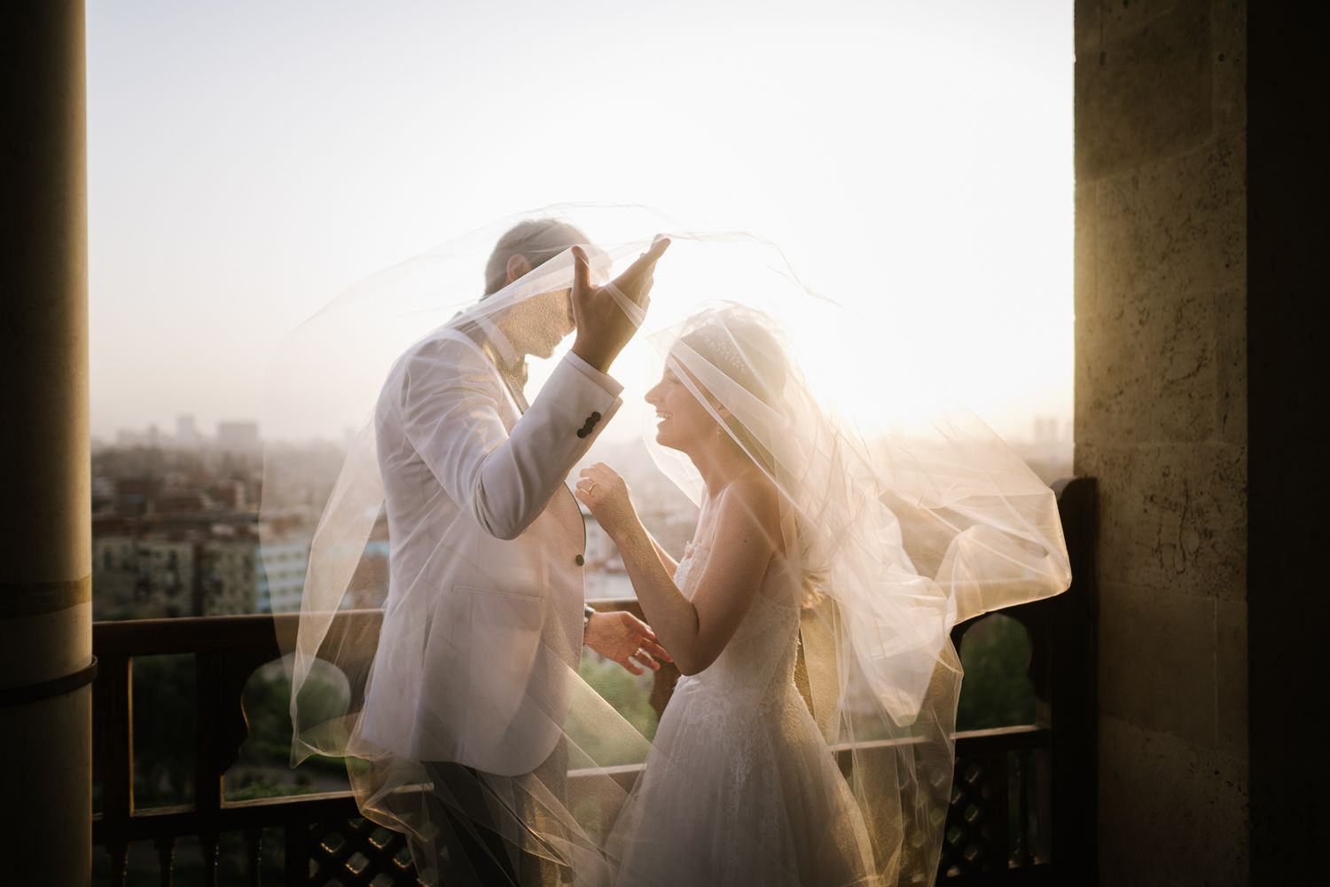 A tender wedding moment captured during golden hour on a city rooftop.