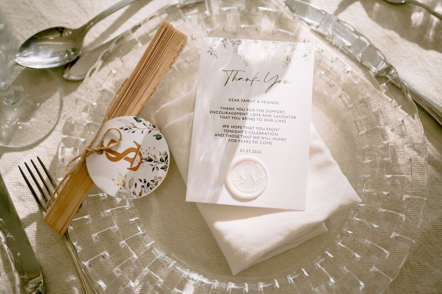 Elegant place setting with crystal plate, cutlery and wedding menu card.
