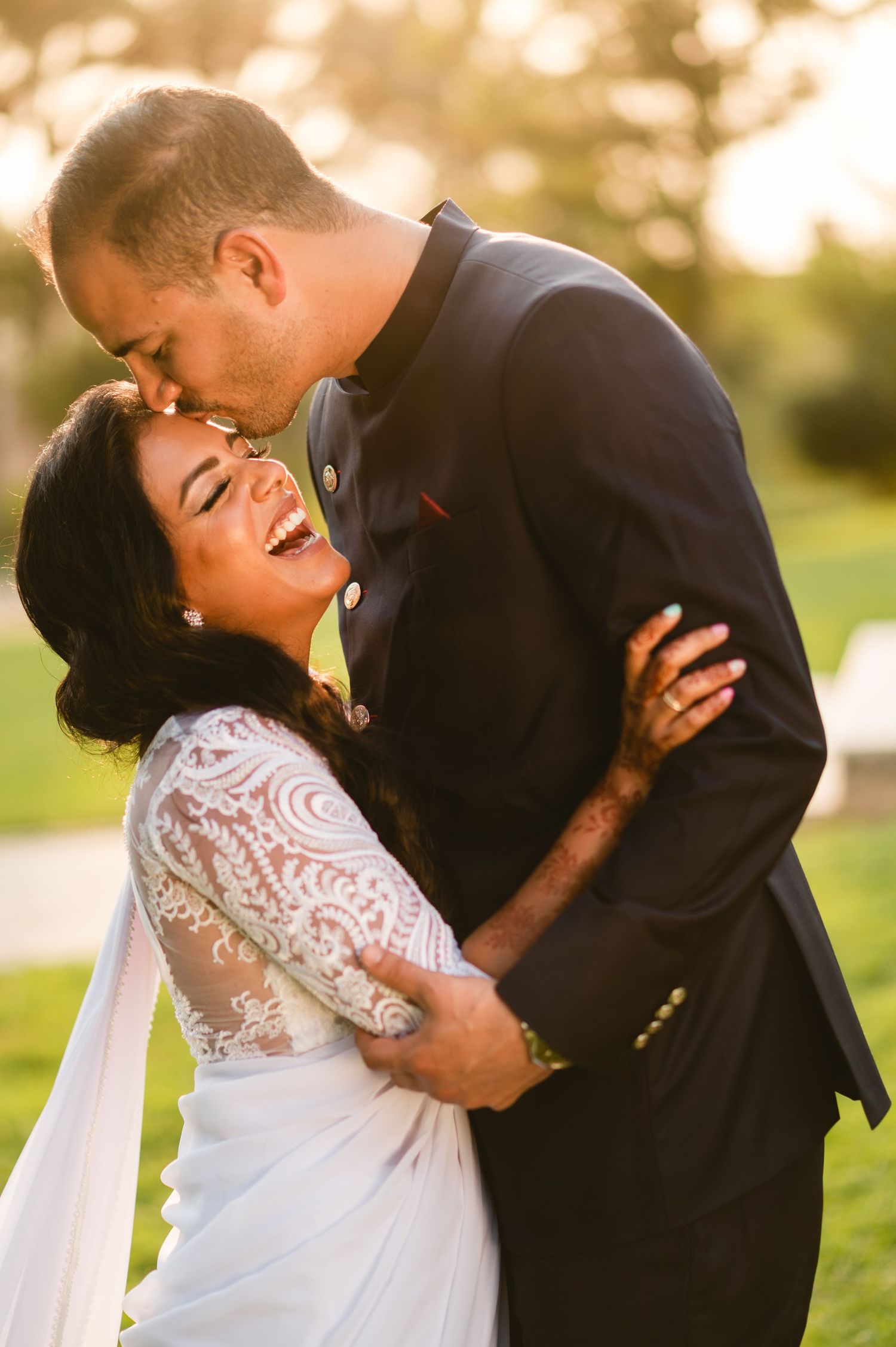 An intimate wedding portrait showing a tender moment between the couple amid golden sunlight.