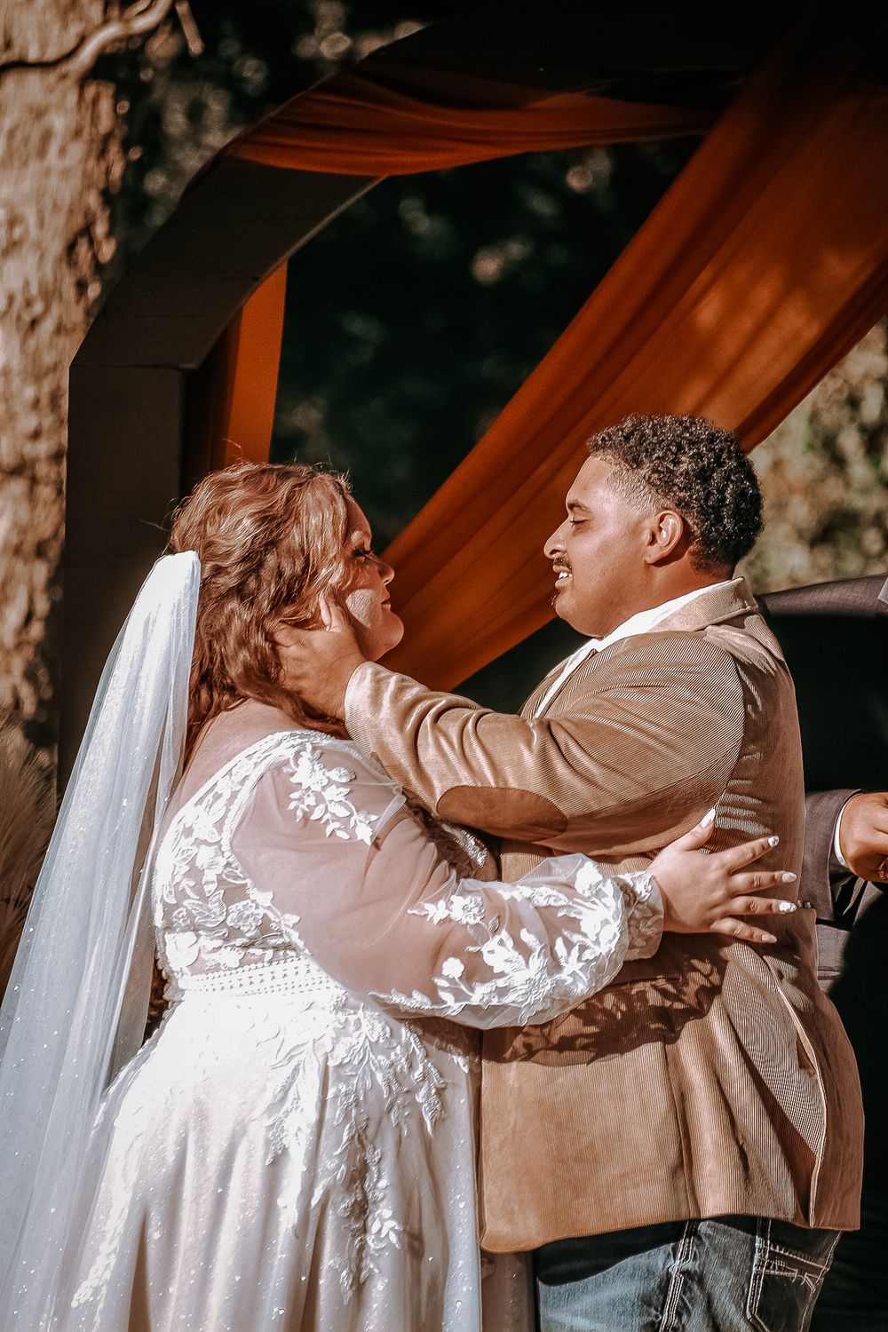 A tender moment between newlyweds embracing during their outdoor wedding ceremony.
