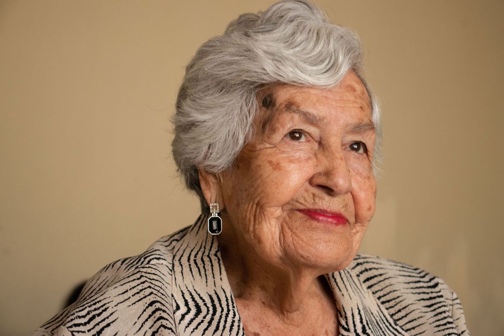 Artistic profile portraits showing silver hair and red lipstick against beige background.