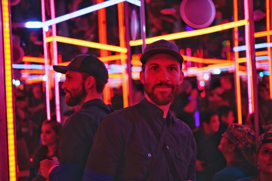 Arkansas nature photographer, Alex Kent takes a selfie in house of mirrors with neon lights. Front and profile view