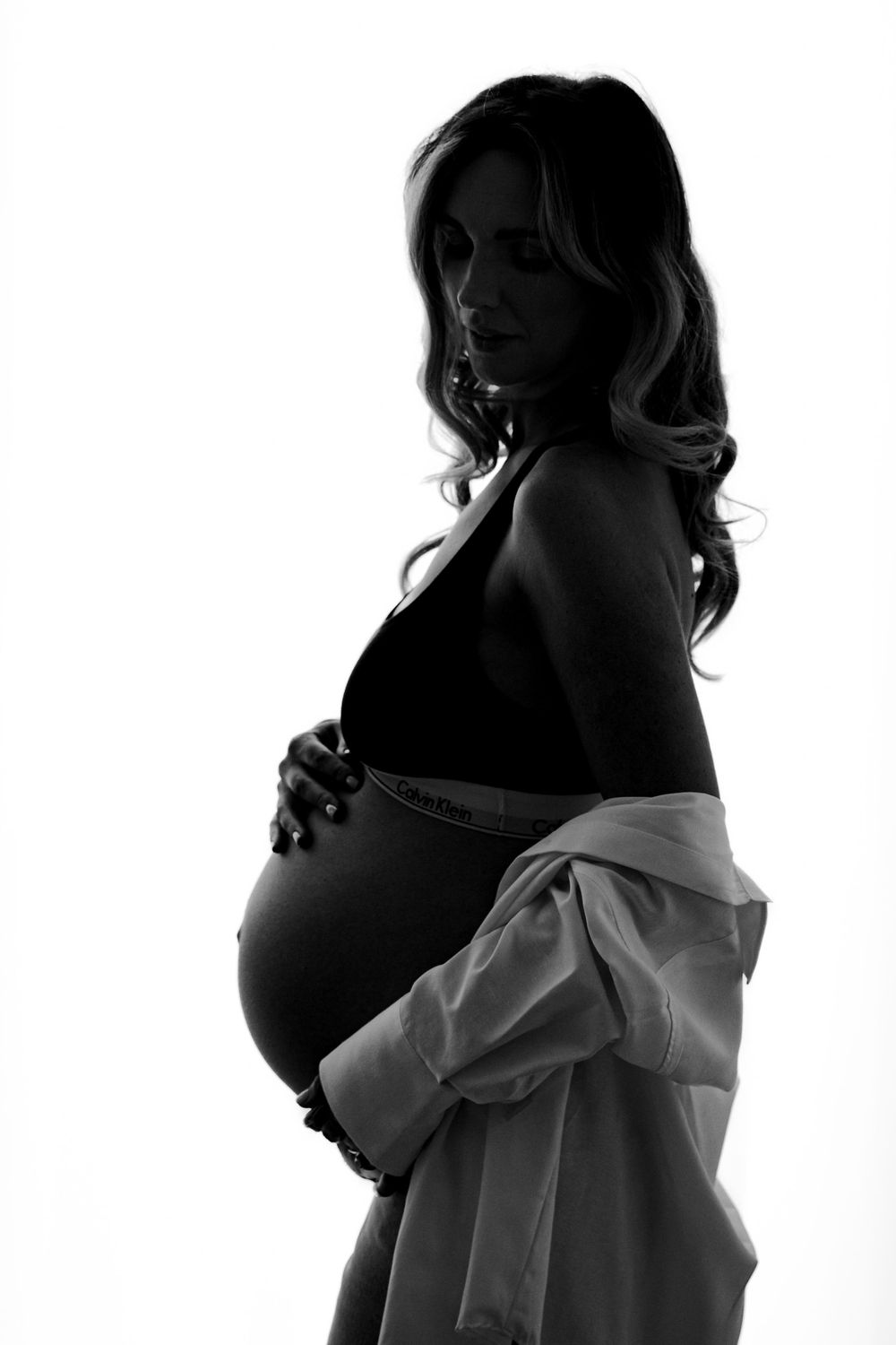 Black and white silhouette of pregnant mother side view