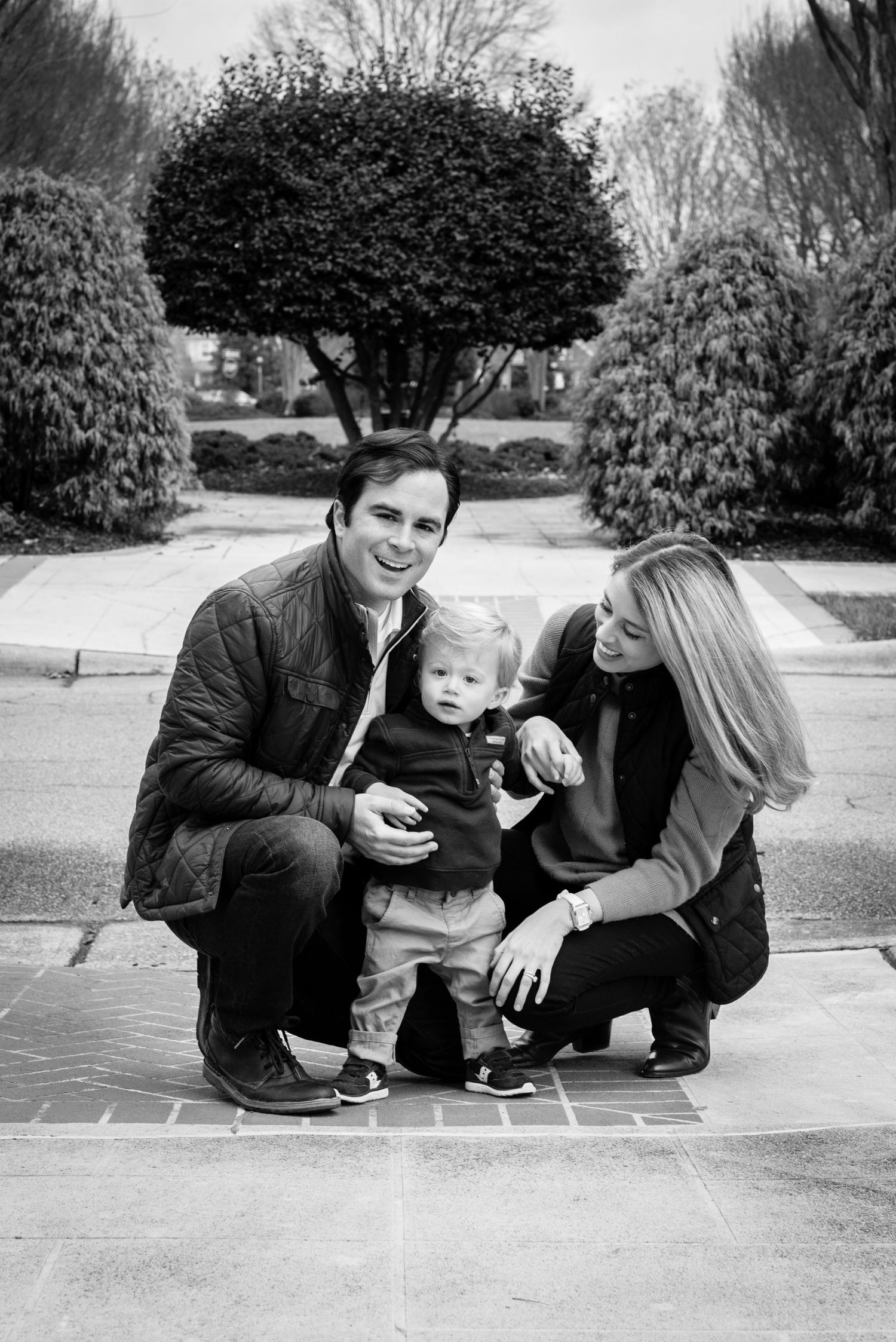 Black and white series of candid family moments on a brick walkway outdoors.