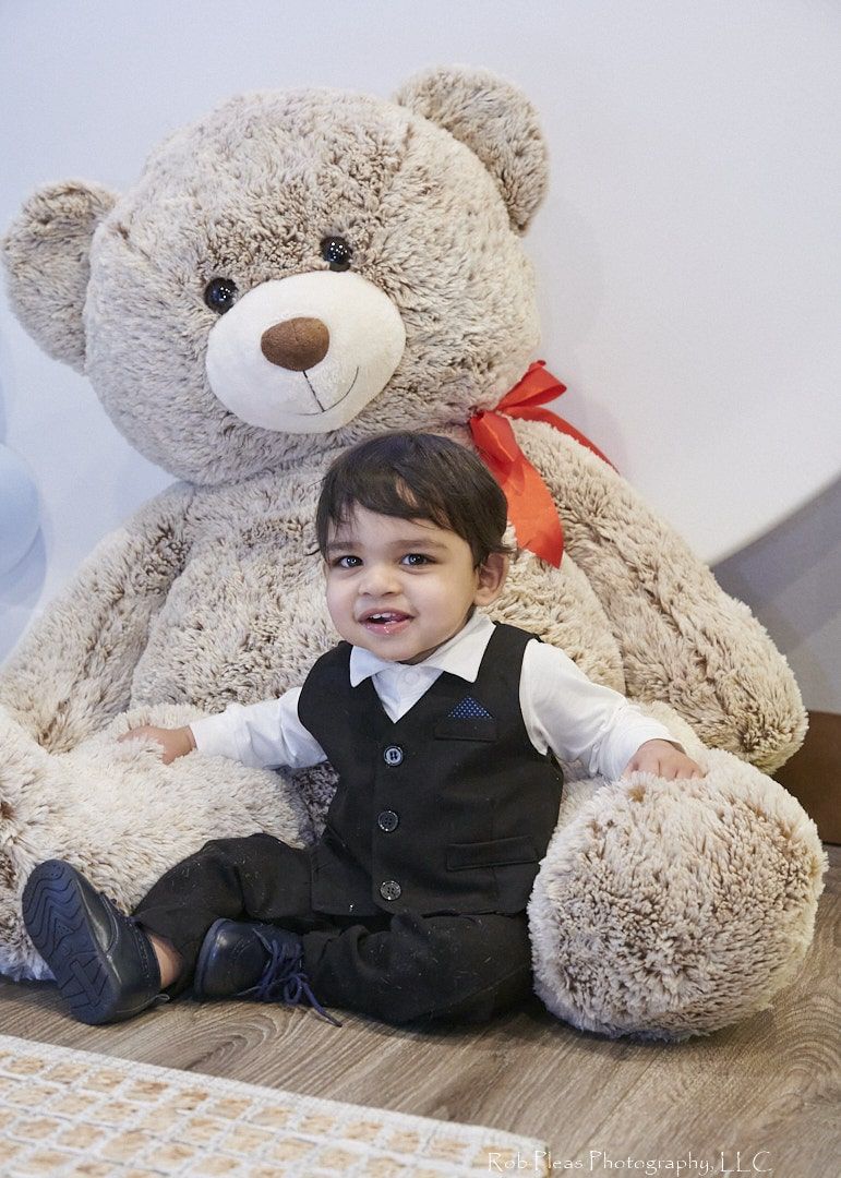 first birthday boy smiling with giant Costco bear