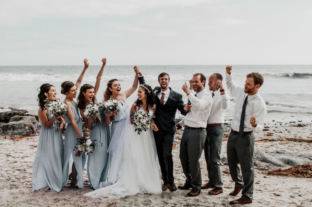 bridal party cheering on bride and groom at crystal cove beach