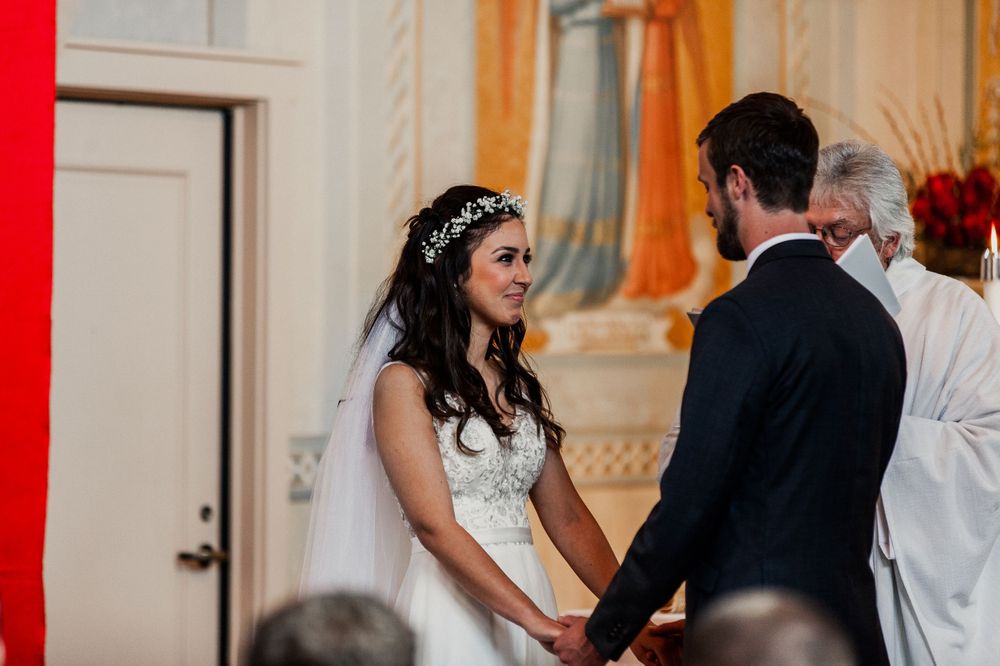 bride and groom at the altar getting blessed from priest