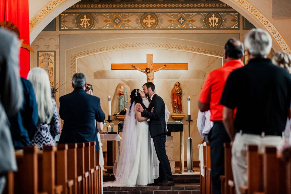 bride and groom first kiss at altar st francis church