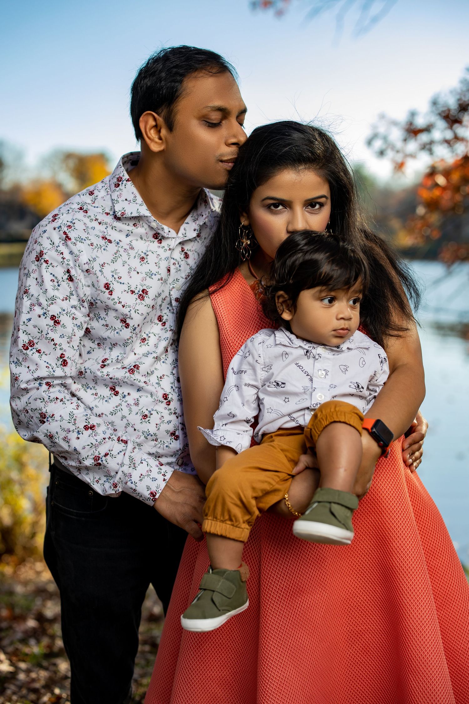 Intimate family portrait by lake during autumn outdoor photo session.
