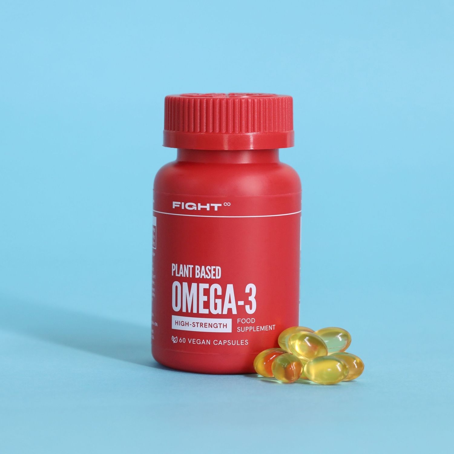 Red bottle of plant-based Omega-3 supplements with gold capsules on blue background.