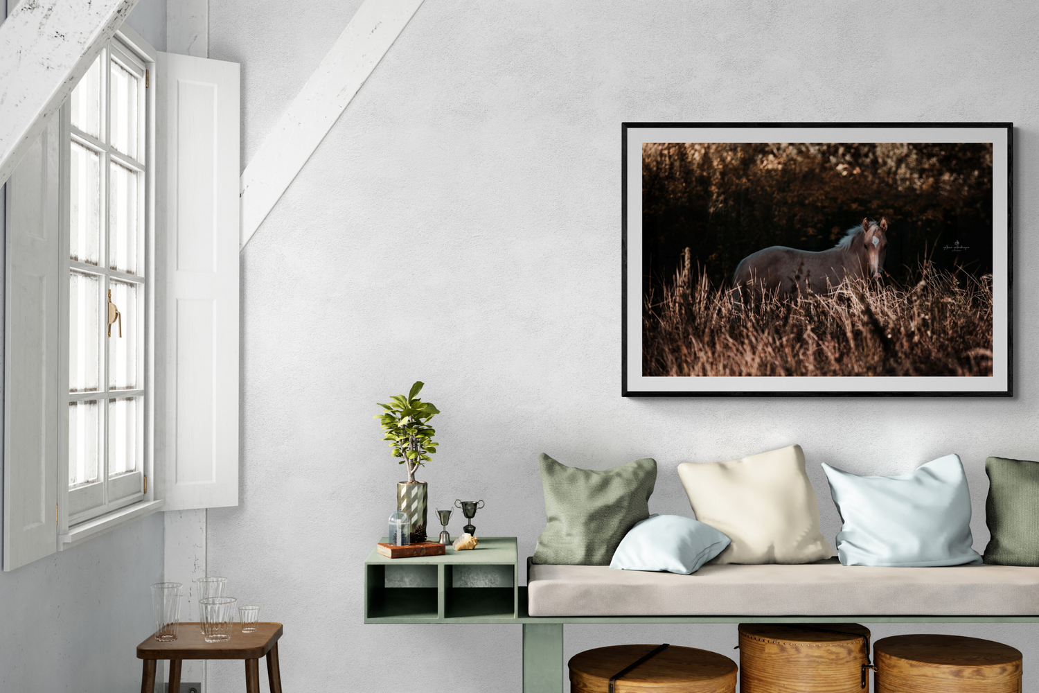 A serene living room with horse artwork displayed above a daybed with pastel pillows and natural lighting.