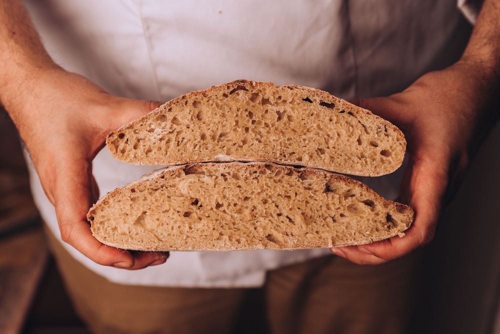 Two halves of freshly baked artisanal sourdough bread showing its airy crumb structure.