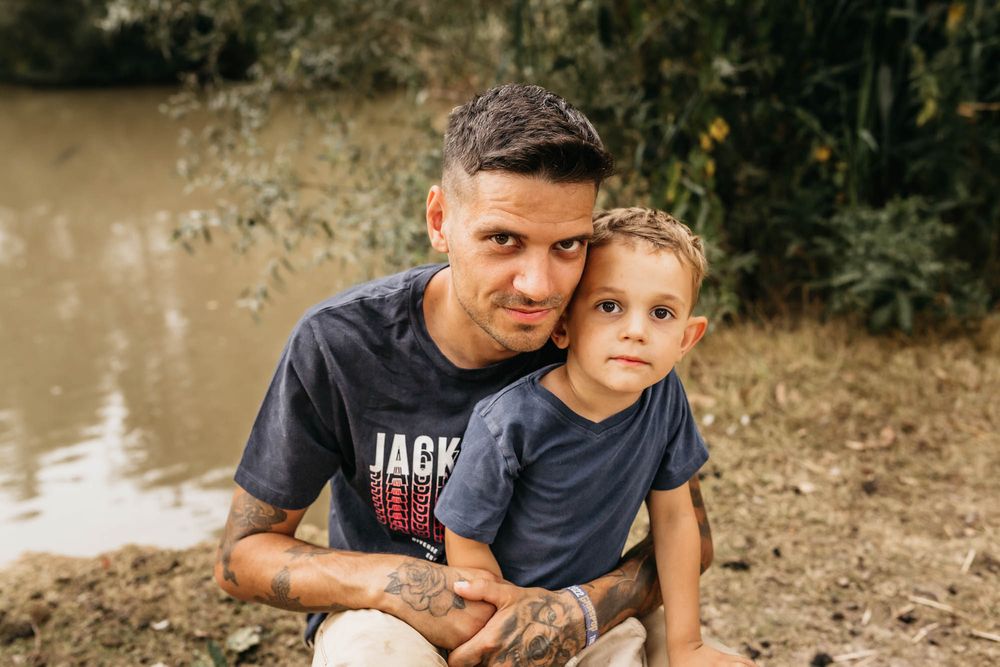 Sweet bonding moment between parent and child sitting by a pond.