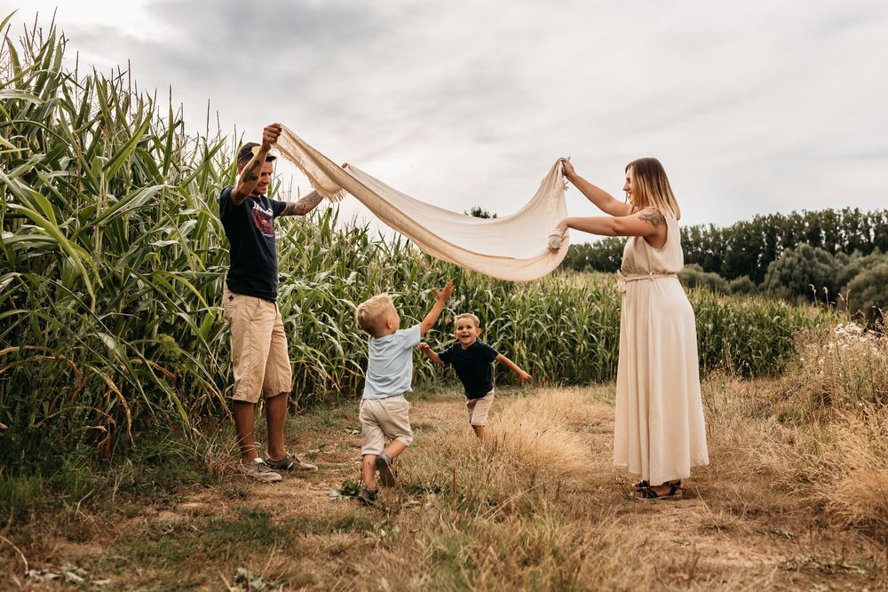 Playing with fabric in a cornfield on a cloudy summer day.