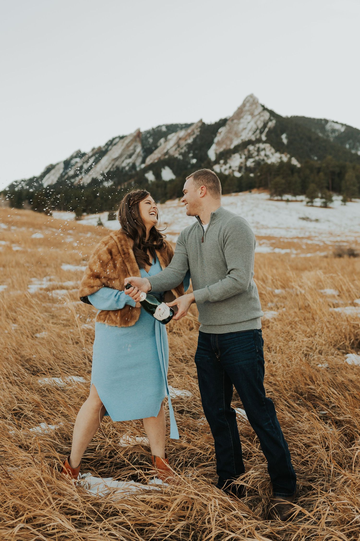 Couple popping champagne at Colorado engagement session.